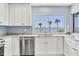 Well-lit kitchen with stainless appliances, white cabinetry, and a large window with ocean views at 1906 Mississippi Ave, Englewood, FL 34224