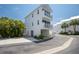 Modern three-story townhouse featuring dual balconies, covered parking, and lush landscaping at 2255 N Beach Rd # 12, Englewood, FL 34223