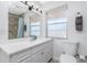 Updated bathroom with white vanity, tile shower, and a window at 2375 N Beach Rd # 2B, Englewood, FL 34223