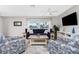 Living room with a navy blue sofa, two armchairs, and a view to a balcony at 2375 N Beach Rd # 2B, Englewood, FL 34223