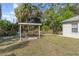 Landscaped backyard area with a covered pergola and a table, perfect for outdoor dining at 2657 Tusket Ave, North Port, FL 34286