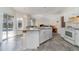 Bright kitchen with tiled floors, an island, and sliding glass doors to the outdoor pool area at 2657 Tusket Ave, North Port, FL 34286