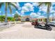 A sunny exterior view of the clubhouse with palm trees and golf cart parking at 2660 Sable Palm Way, Port Charlotte, FL 33953