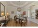 Formal dining room featuring elegant lighting, tray ceilings, and hardwood floors at 2660 Sable Palm Way, Port Charlotte, FL 33953