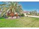 Beautiful landscaping with palm trees, colorful plants, and a lush green lawn enhance this home's curb appeal at 2660 Sable Palm Way, Port Charlotte, FL 33953