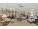 Well-lit living room with hardwood floors, a ceiling fan, and an open view into the kitchen area at 2660 Sable Palm Way, Port Charlotte, FL 33953