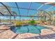 Beautiful screened-in pool and spa area surrounded by lush landscaping and a tranquil lake view at 2660 Sable Palm Way, Port Charlotte, FL 33953