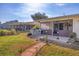 Backyard featuring a screened lanai, lush green grass, landscaping, and a brick walkway at 3204 Depew Ave, Port Charlotte, FL 33952