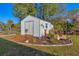 Backyard featuring a storage shed, landscaping with bright flowers and a ramp for easy access at 3204 Depew Ave, Port Charlotte, FL 33952