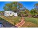 Backyard featuring a storage shed, landscaping, a brick walkway and lush green grass at 3204 Depew Ave, Port Charlotte, FL 33952