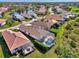 Charming neighborhood aerial shot of tiled roof homes with screened in lanai's and green lawns near a pond at 3307 Osprey Ln, Port Charlotte, FL 33953