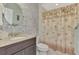 Bathroom featuring decorative stone wall, stylish vanity, and a shower with a decorative palm tree curtain at 3307 Osprey Ln, Port Charlotte, FL 33953