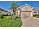 Well-maintained home features a two-car garage, lush landscaping, and a welcoming facade at 3307 Osprey Ln, Port Charlotte, FL 33953