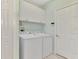 Bright laundry room with washer, dryer, and overhead cabinets for storage at 3307 Osprey Ln, Port Charlotte, FL 33953