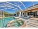 Outdoor living at its finest, featuring a beautiful pool, hot tub, and covered patio with lounge chairs at 3307 Osprey Ln, Port Charlotte, FL 33953