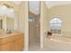 Bright bathroom featuring a tub, tiled shower, modern vanity, and arched window at 43 Blue Hen Dr, Placida, FL 33946