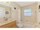 Bathroom with single sink vanity, tub and shower combination, and neutral colored tile at 43 Blue Hen Dr, Placida, FL 33946