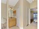 View of the bathroom leading to the bedroom with an oak vanity and white cabinets at 43 Blue Hen Dr, Placida, FL 33946