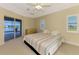 Bedroom offering sliding glass door to the screened patio and windows with blinds for natural light at 43 Blue Hen Dr, Placida, FL 33946