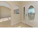 Bright foyer featuring tile flooring, decorative entry door, and archway at 43 Blue Hen Dr, Placida, FL 33946