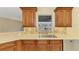 Kitchen sink area featuring wooden cabinets, light countertops, mosaic tile backsplash, and a window view at 43 Blue Hen Dr, Placida, FL 33946