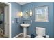 Small bathroom with pedestal sink, toilet and blue walls at 5 Pointe Way, Placida, FL 33946