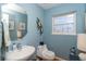 Small half bathroom with pedestal sink and blue walls at 5 Pointe Way, Placida, FL 33946