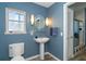 Bathroom with pedestal sink, toilet and blue walls at 5 Pointe Way, Placida, FL 33946