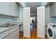 Bright laundry room, washer, dryer, utility sink, and built-in cabinets at 5 Pointe Way, Placida, FL 33946