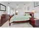 Comfortable bedroom featuring light tile flooring, a ceiling fan, and a queen-size bed with decorative green pattern comforter at 5031 Lucine Rd, Venice, FL 34293