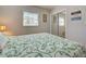 Bedroom featuring light tile flooring, a comfortable queen bed with decorative green pattern comforter and window view at 5031 Lucine Rd, Venice, FL 34293