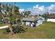 Exterior elevation showing landscaped yard and mature shade trees at 5031 Lucine Rd, Venice, FL 34293