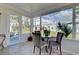 Cozy sunroom with table set, bright windows showing fenced yard, and door to the outside at 5031 Lucine Rd, Venice, FL 34293