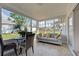 Comfortable sunroom featuring sofa with pillows and a dining set, overlooking the fenced in backyard at 5031 Lucine Rd, Venice, FL 34293