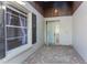 Covered entryway with brick flooring, a light blue front door, and large window at 525 Foxwood Blvd, Englewood, FL 34223