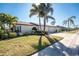 Charming single-story home with a well-manicured lawn and tropical palm trees creating curb appeal at 525 Foxwood Blvd, Englewood, FL 34223