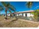 The home's exterior showing lush, green landscaping and a white fence at 525 Foxwood Blvd, Englewood, FL 34223