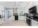 Bright kitchen with stainless steel appliances, granite countertops, and white cabinetry at 525 Foxwood Blvd, Englewood, FL 34223