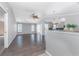 Bright, open living room featuring wood floors, neutral walls, ceiling fan, and view into the kitchen at 525 Foxwood Blvd, Englewood, FL 34223