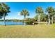 Scenic pond with a fountain, framed by palm trees and lush green lawn, creating a serene atmosphere at 525 Foxwood Blvd, Englewood, FL 34223