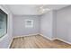 Bright bedroom featuring wood-look floors, a ceiling fan, a window, and neutral paint colors at 5280 Grobe St, North Port, FL 34287