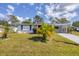 A charming single-story home featuring a well-maintained lawn and attractive landscaping with palm trees at 5280 Grobe St, North Port, FL 34287