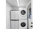 Efficient laundry area with a stacked washer and dryer unit, and a storage cabinet at 5280 Grobe St, North Port, FL 34287