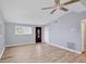 A living room with laminate floors, a ceiling fan, and natural light from the windows at 5280 Grobe St, North Port, FL 34287