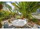 Lush backyard area featuring a table surrounded by tropical plants and landscaping at 621 Tarpon Way, Punta Gorda, FL 33950