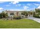 Quaint yellow house with red door, striped awnings and neatly landscaped yard at 621 Tarpon Way, Punta Gorda, FL 33950