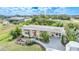 Aerial shot of a cozy home surrounded by tropical plants, featuring awnings, a carport, and a lush green lawn at 621 Tarpon Way, Punta Gorda, FL 33950