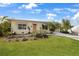 Charming single-story home with a well-manicured lawn, vibrant landscaping, and a welcoming front entrance under a sunny sky at 621 Tarpon Way, Punta Gorda, FL 33950