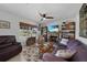 Cozy living room features a stone fireplace, ceiling fan, comfortable furniture, and natural light at 621 Tarpon Way, Punta Gorda, FL 33950