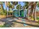 Charming art studio with a colorful exterior and inviting entrance nestled among tropical palm trees and lush foliage at 681 Olive St, Englewood, FL 34223